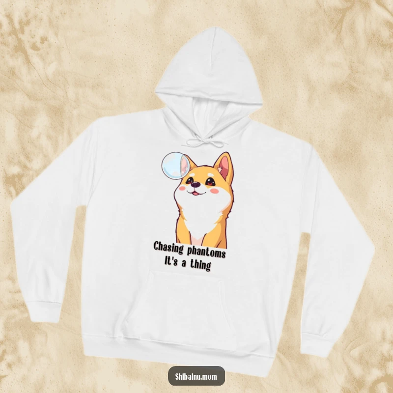 Funny Shiba Inu hoodie, a curious dog gazes upward at a floating bubble, showcasing cheerful fascination and cozy vibes.